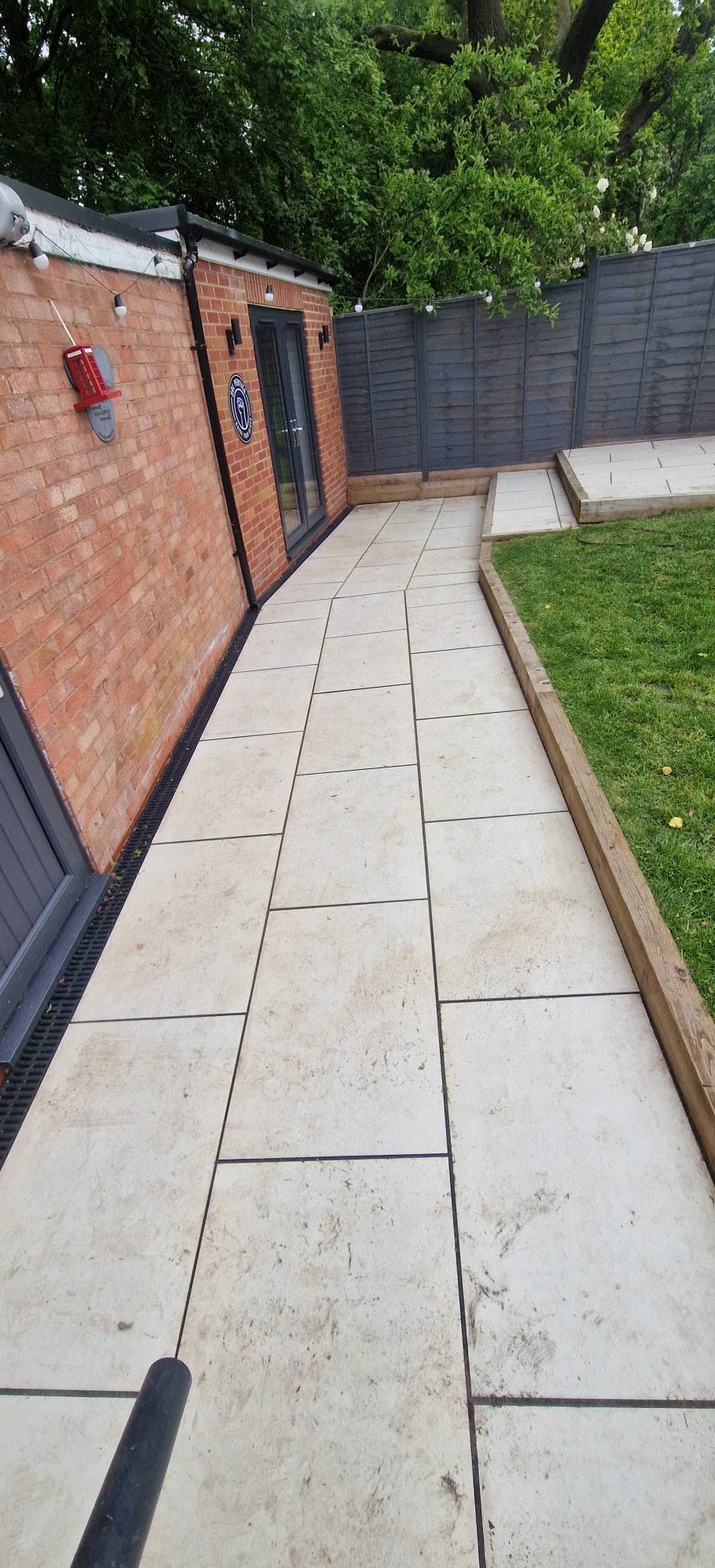 Marked and dirt-stained porcelain patio walkway before cleaning