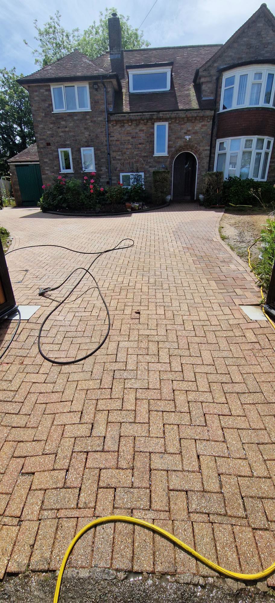 The same block paved driveway cleaned back to bright herringbone brick