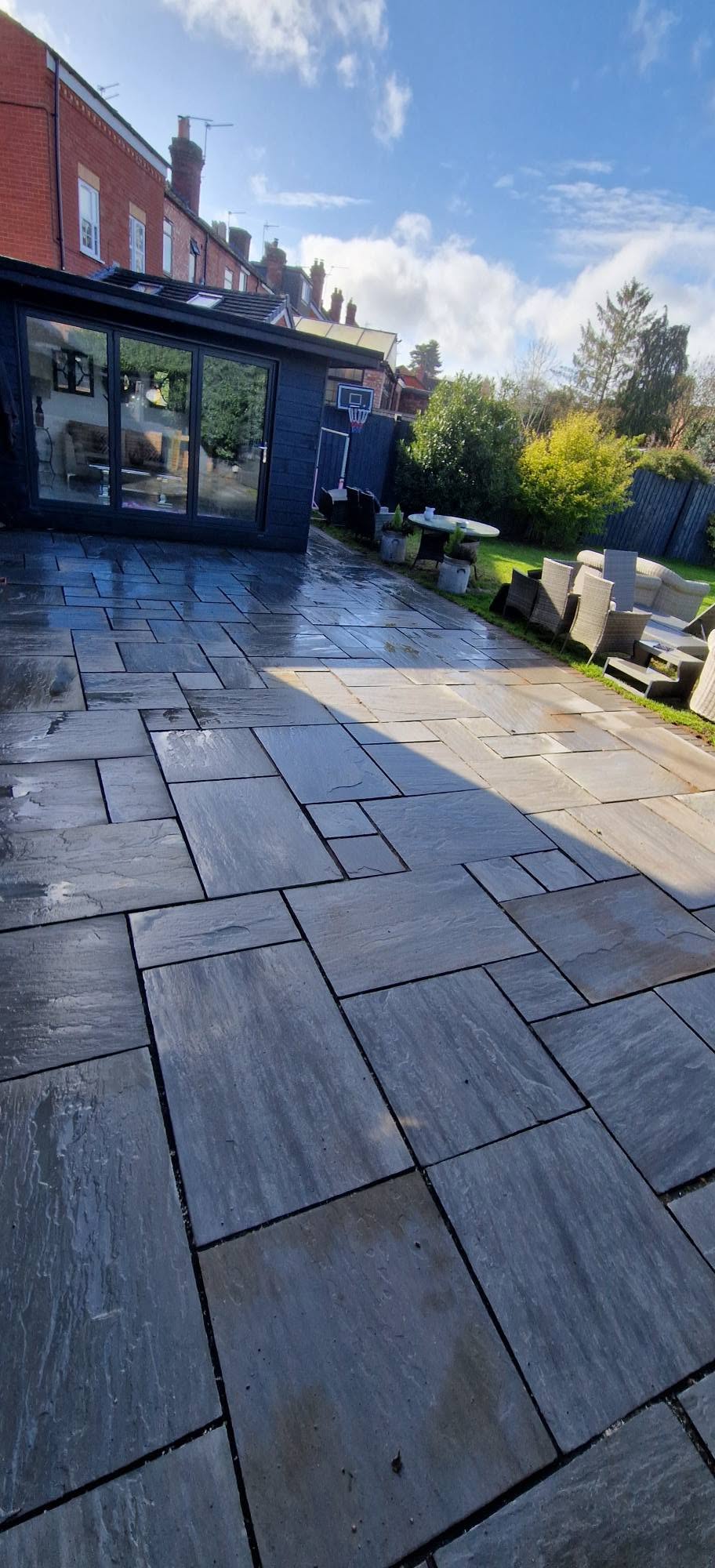 The same large rear patio pressure washed clean across every slab